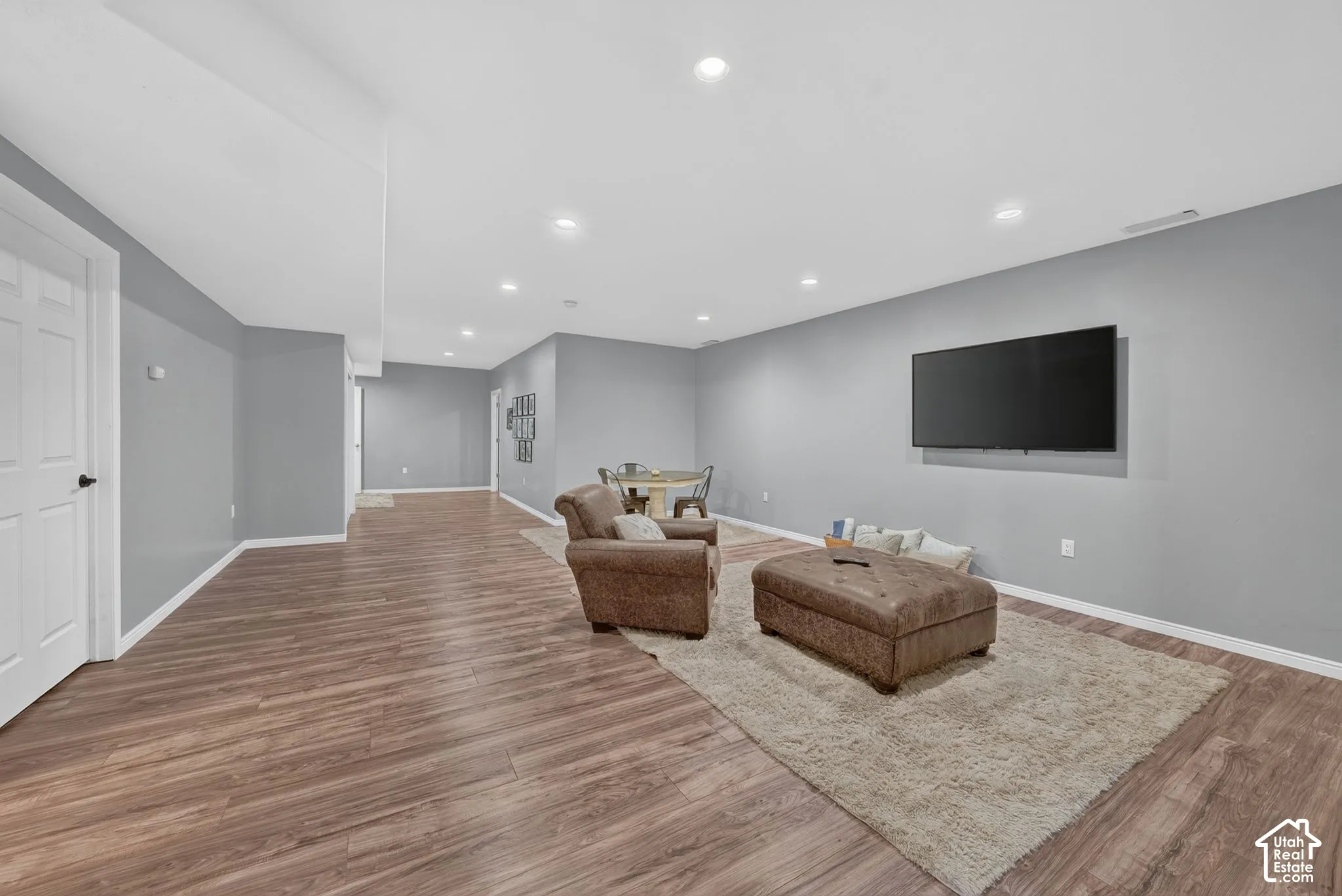 Expansive room featuring wood-finish flooring, recessed lighting, and a neutral wall color