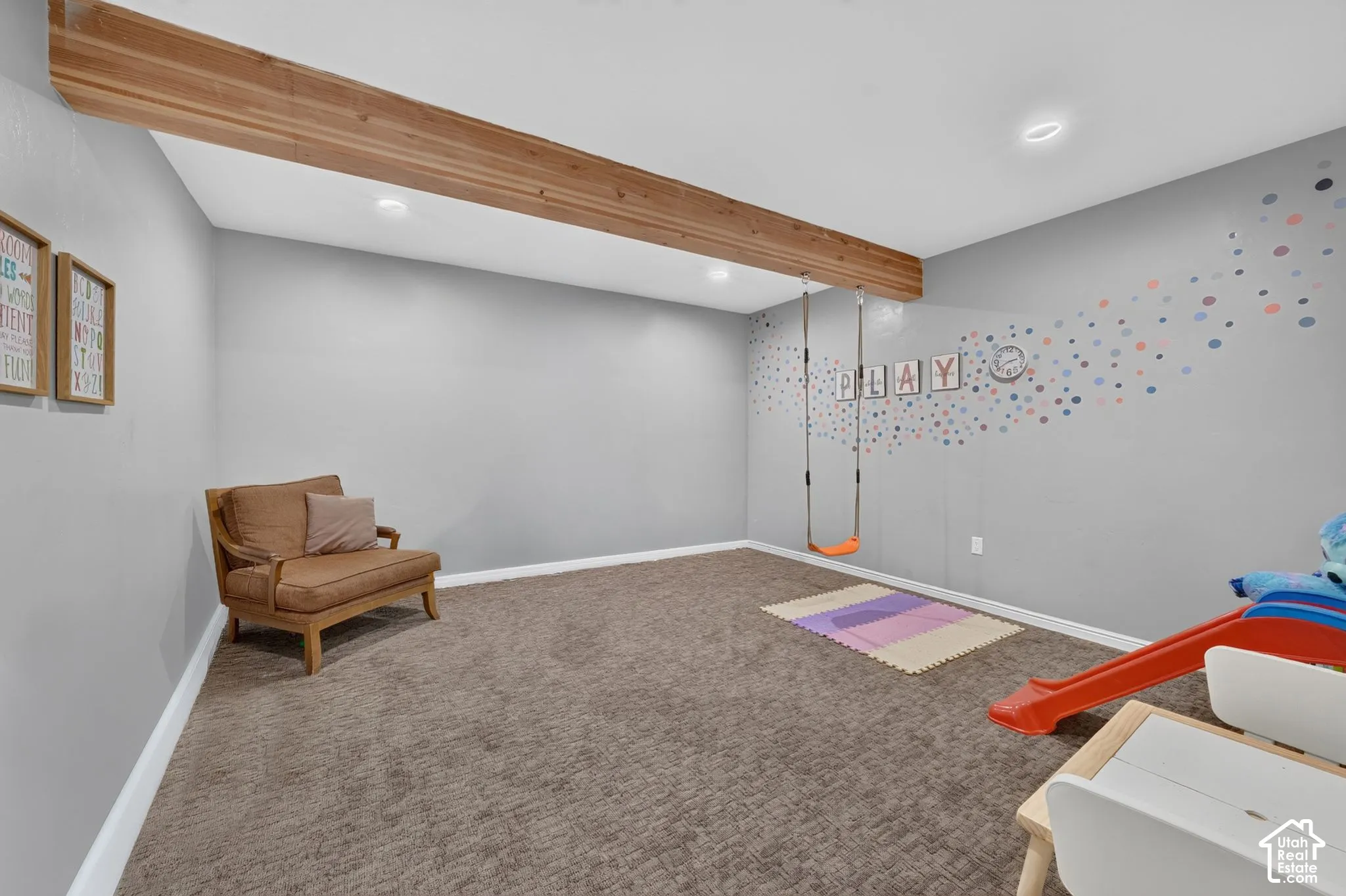 Recessed lighting illuminates the carpeted flooring and light grey walls