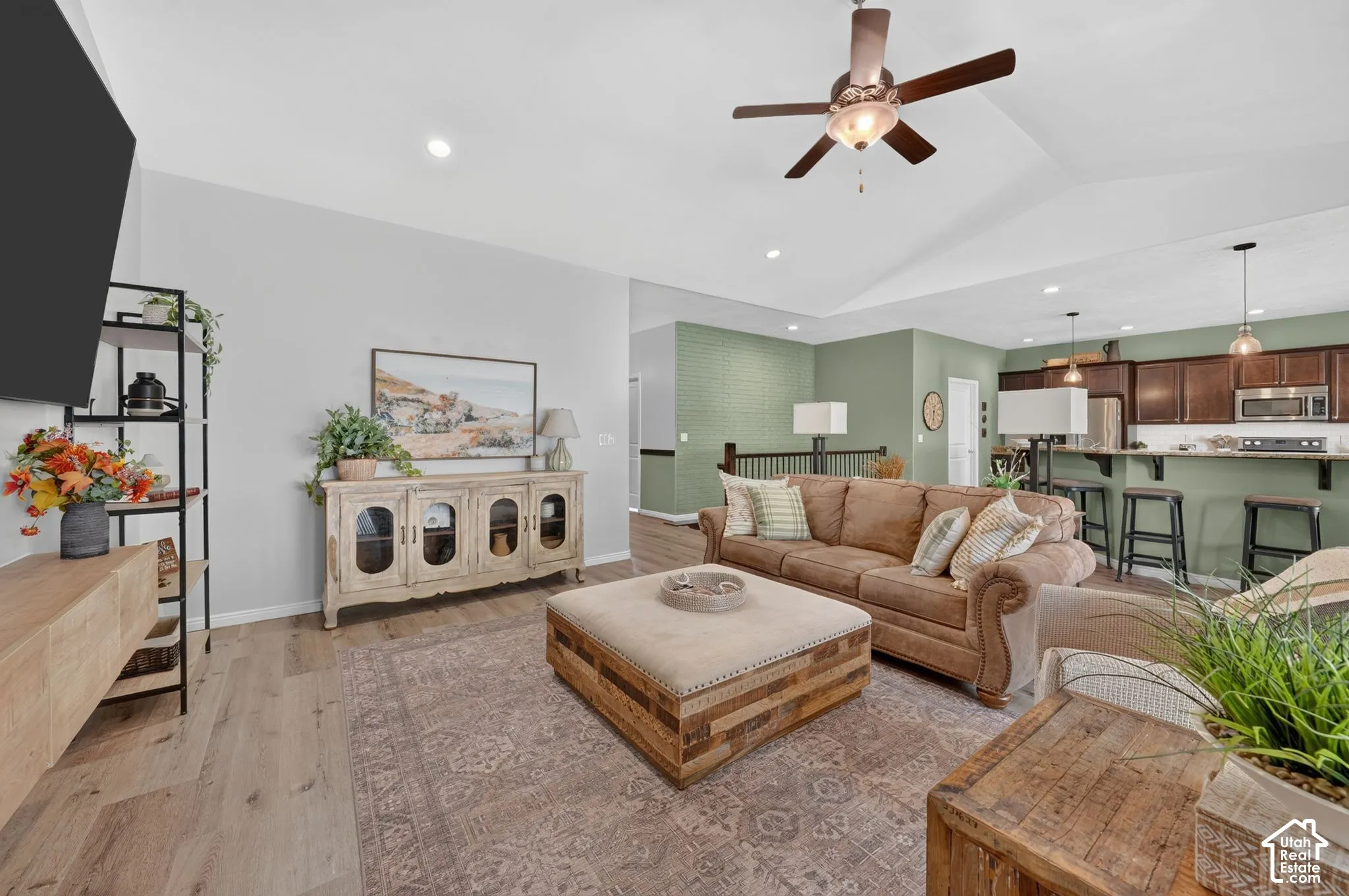 Wood-finish flooring, recessed lighting, and a vaulted ceiling with a ceiling fan