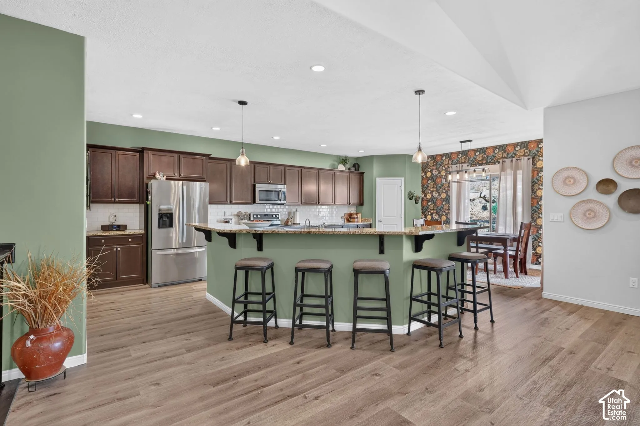 Kitchen with wood-finish flooring, recessed lighting, and a peninsula with pendant lights