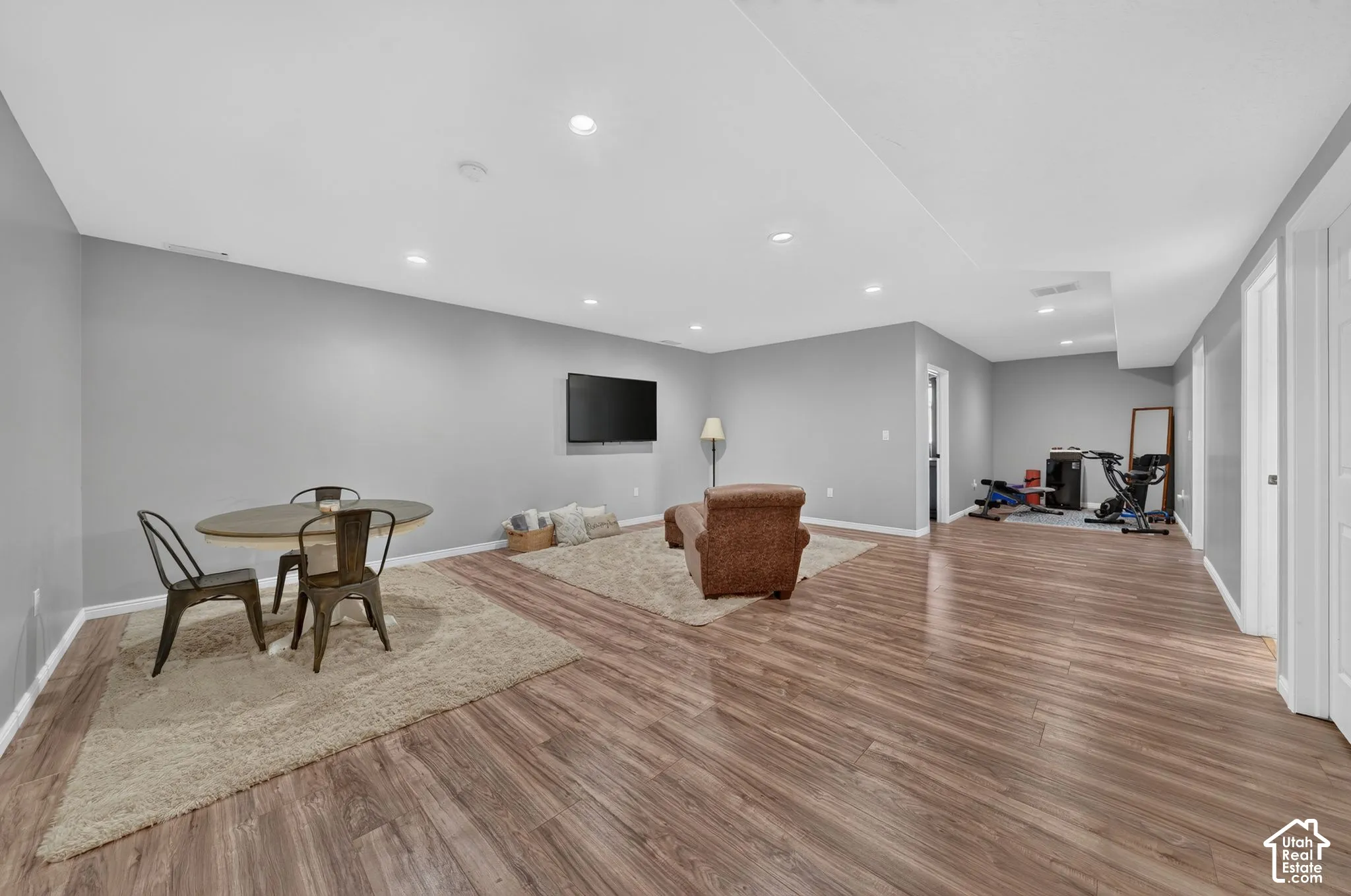 Spacious room featuring wood-finish flooring, recessed lighting, and light gray walls
