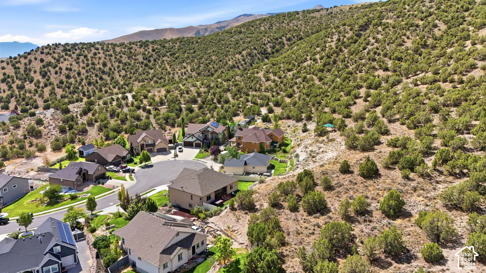 Residential neighborhood at the base of a brush-covered hillside
