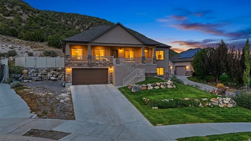 Multi-level exterior with stone accents, a covered front porch, and an integrated garage