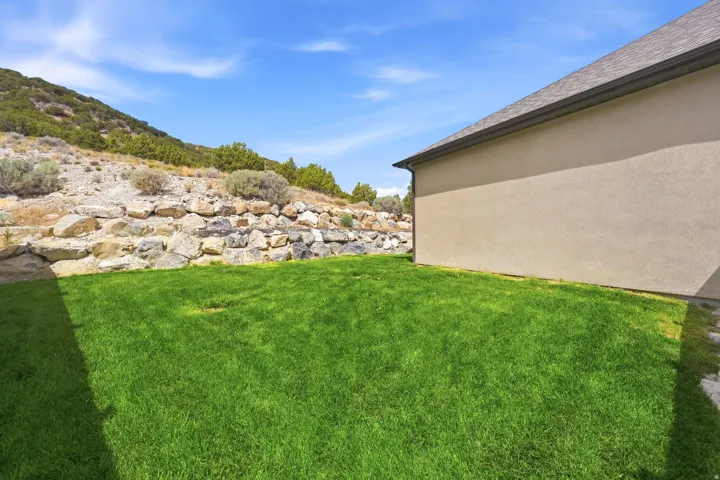 Expansive lawn area with a natural rock retaining wall