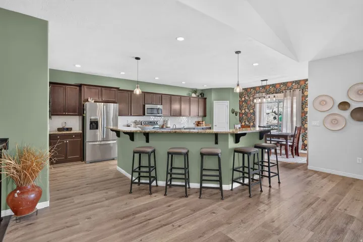 Kitchen with wood-finish flooring, recessed lighting, and a peninsula with pendant lights