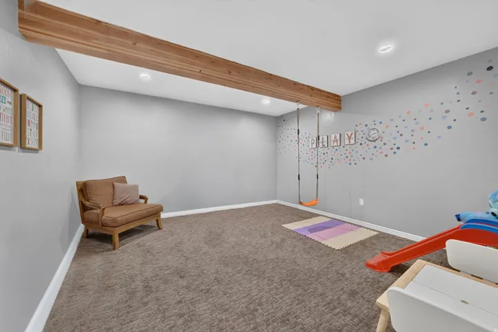 Recessed lighting illuminates the carpeted flooring and light grey walls