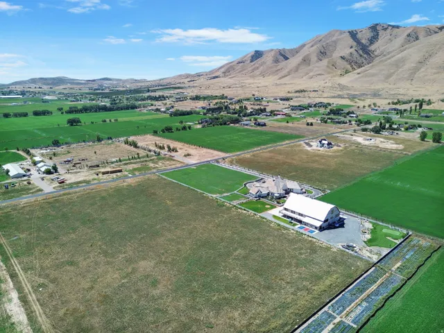 Expansive agricultural setting with a large residential structure, a substantial outbuilding, and a putting green
