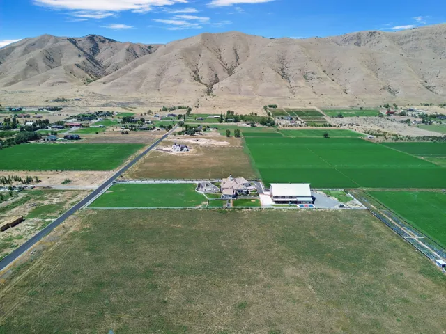 Expansive property featuring a residence, manicured lawns, and adjacent agricultural fields