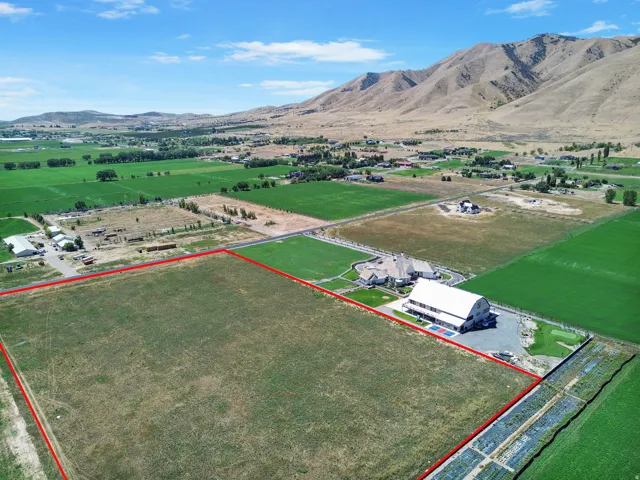 Expansive land parcel with surrounding agricultural fields, distant mountain range, and a visible property boundary