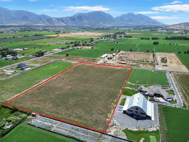 Expansive undeveloped land parcel with a mountainous backdrop and surrounding agricultural fields