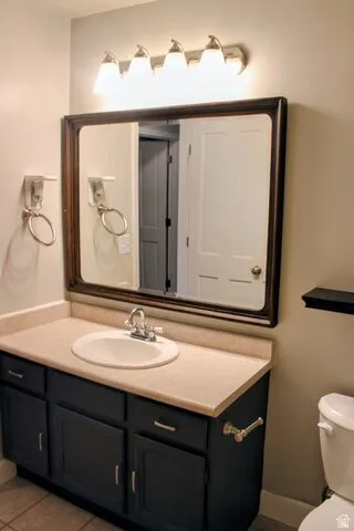 Bathroom vanity featuring a framed mirror, a four-light fixture, an integrated sink, a two-door cabinet, and a two-drawer cabinet
