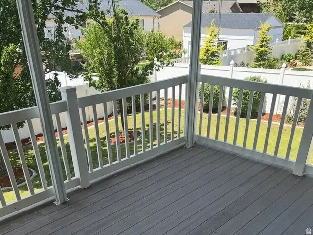 Spacious deck featuring composite decking, white railing, and a manicured lawn