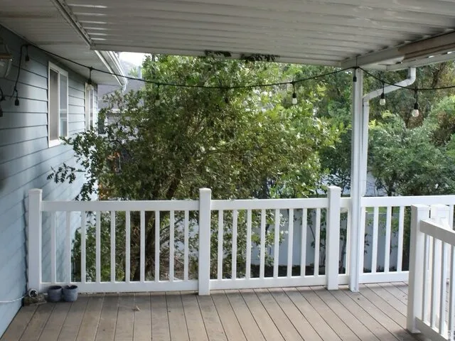 Covered deck with wood-finish flooring and white railings