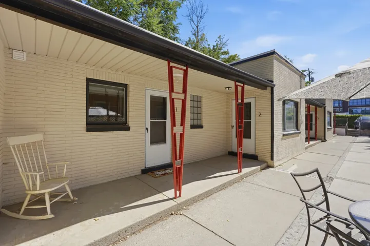 Mid-century design character highlighting retro-style decorative support pillars, clean-painted brick, glass block window accents, and covered porches.