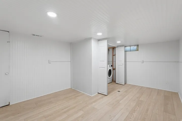 [Unit 3] Dedicated laundry space featuring side-by-side full-size washer and dryer hookups with clean, closed-door storage and easy water heater access.