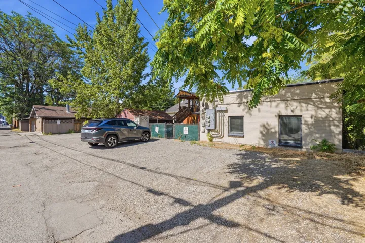 Spacious gravel parking area located directly behind the property, accessible via alleyway with dedicated off-street parking options.