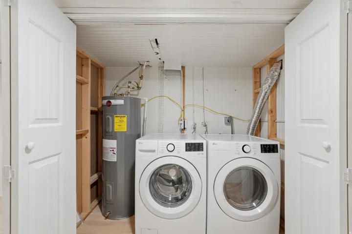 [Unit 3] Dedicated laundry space featuring side-by-side full-size washer and dryer hookups with clean, closed-door storage and easy water heater access.