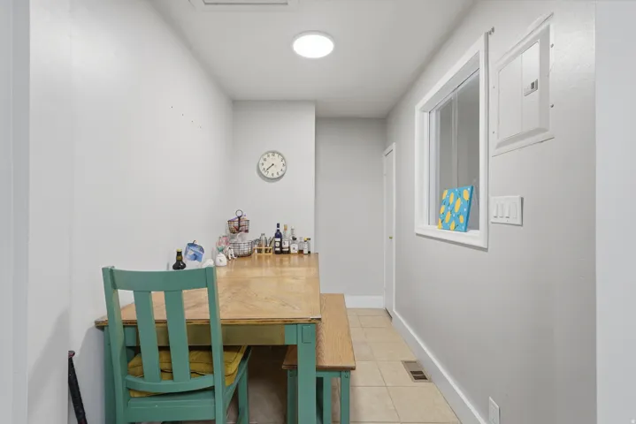[Unit 1] Cozy dining nook adjacent to the kitchen, offering low-maintenance tile flooring and flexible seating arrangement options.
