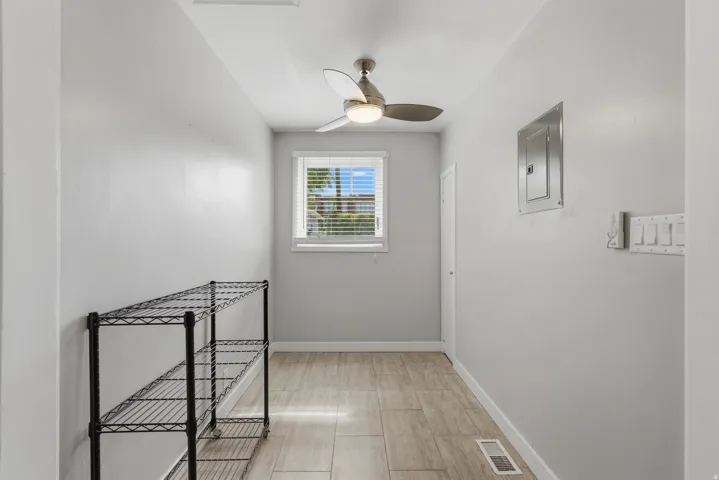 [Unit 3] Flexible dining nook or pantry space featuring modern tile flooring, an updated overhead ceiling fan, natural window lighting, and built-in closet access.