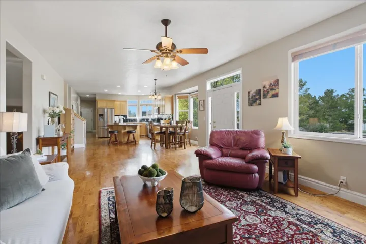 Open-concept living space featuring wood-finish flooring, recessed lighting, and a ceiling fan