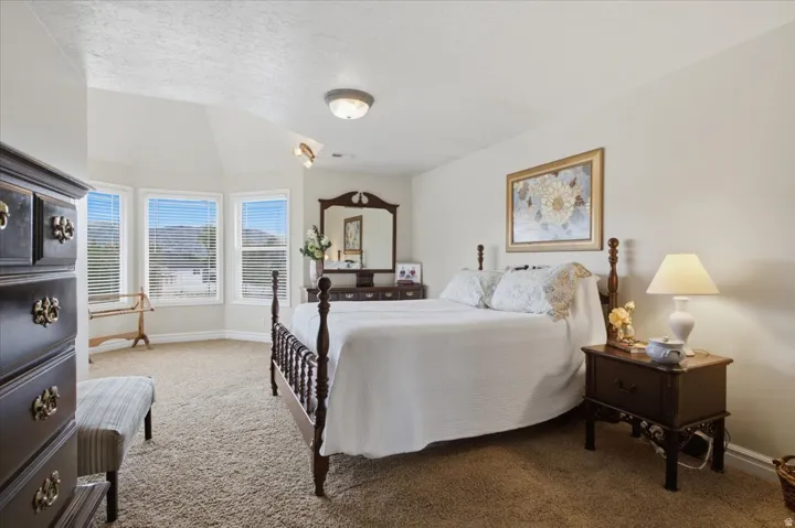 Primary Suite, Carpeted flooring, vaulted ceiling, and bay windows with blinds