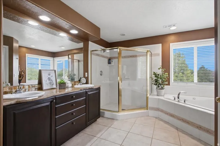 Primary Suite, Dual vanity with undermount sinks, a tiled shower enclosure, a built-in jetted tub, and tiled flooring
