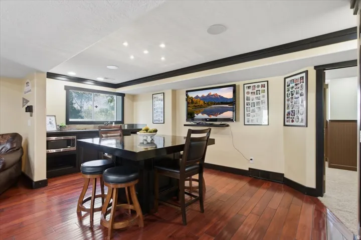 Hardwood flooring, recessed lighting, built-in cabinetry, integrated microwave, and a large window