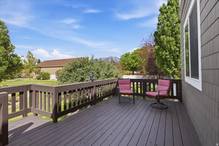 Expansive outdoor deck with a wood railing and panel siding
