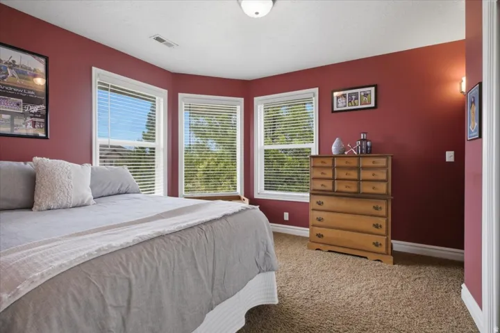 Spacious room featuring multiple windows, neutral carpet flooring, and a flush mount ceiling light