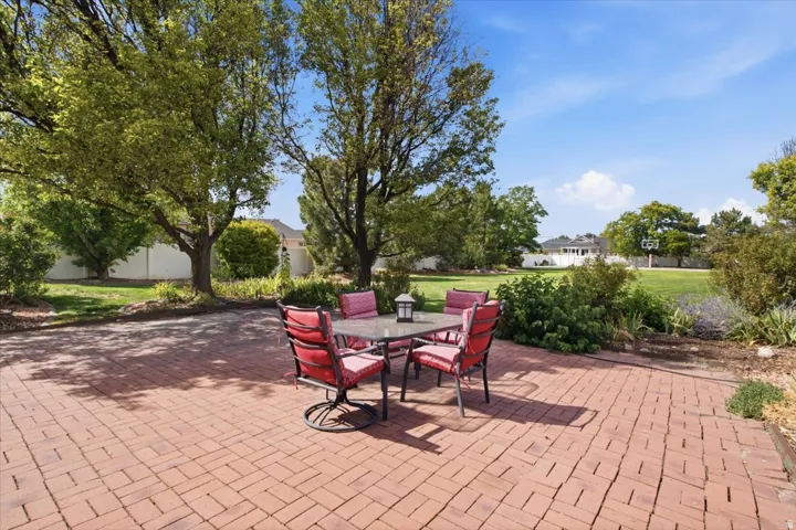 Brick paver patio with mature trees and landscaped planting beds