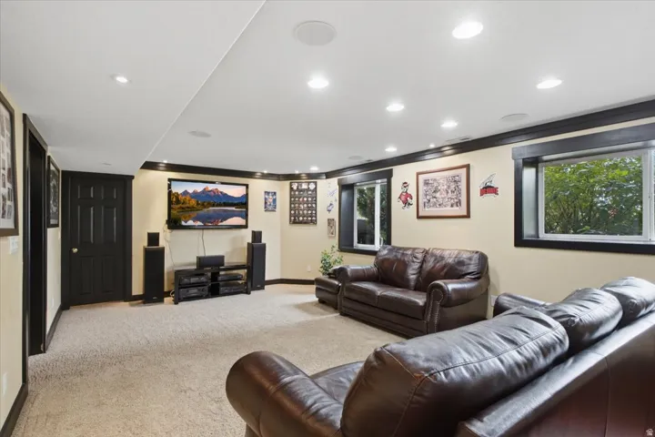 Recessed lighting, light-toned carpeting, wood-frame windows, built-in ceiling speakers, and dark trim accents