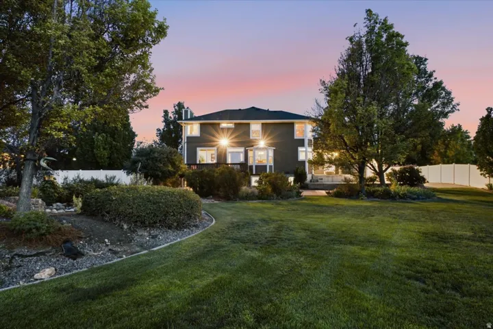 Expansive backyard with a manicured lawn, mature trees, and landscaping elements
