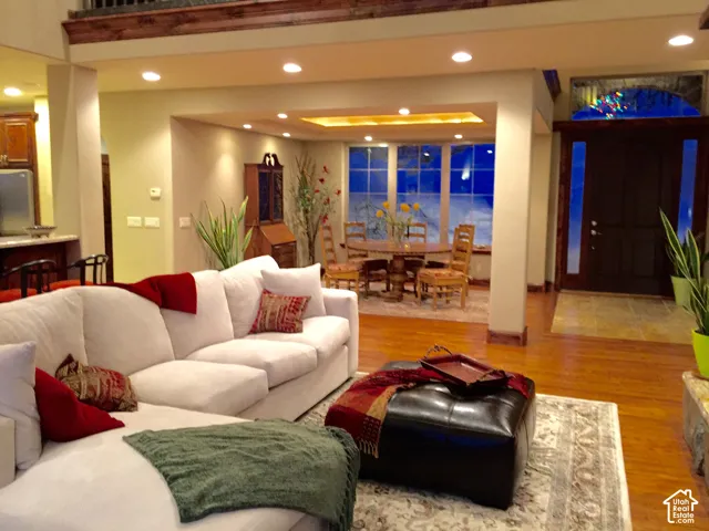 Hardwood flooring throughout, recessed lighting, and a detailed wood beam ceiling accent