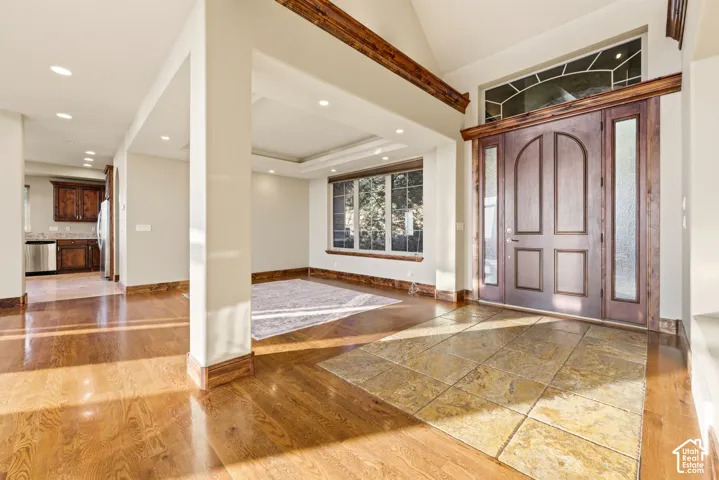Hardwood flooring, recessed lighting, and a tray ceiling with crown molding