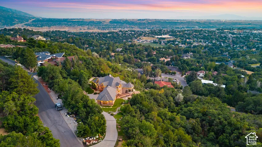 Wood-shingle roofline, stone exterior, and expansive surrounding greenery