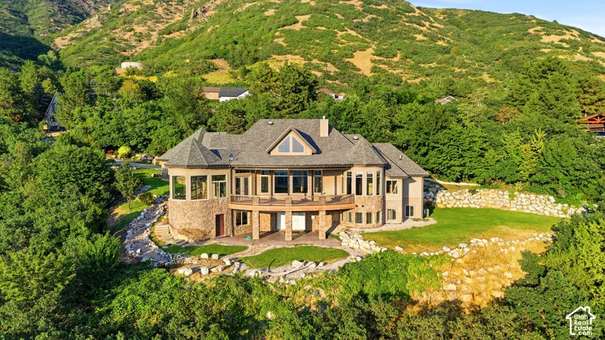Multi-level stone and stucco exterior with multiple balconies and patios
