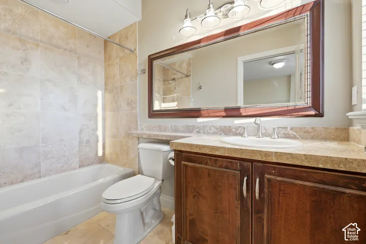Daylight level master suite bathroom.  Featuring a white bathtub, tiled shower surround, wood-finish vanity with a built-in sink, and a large framed mirror