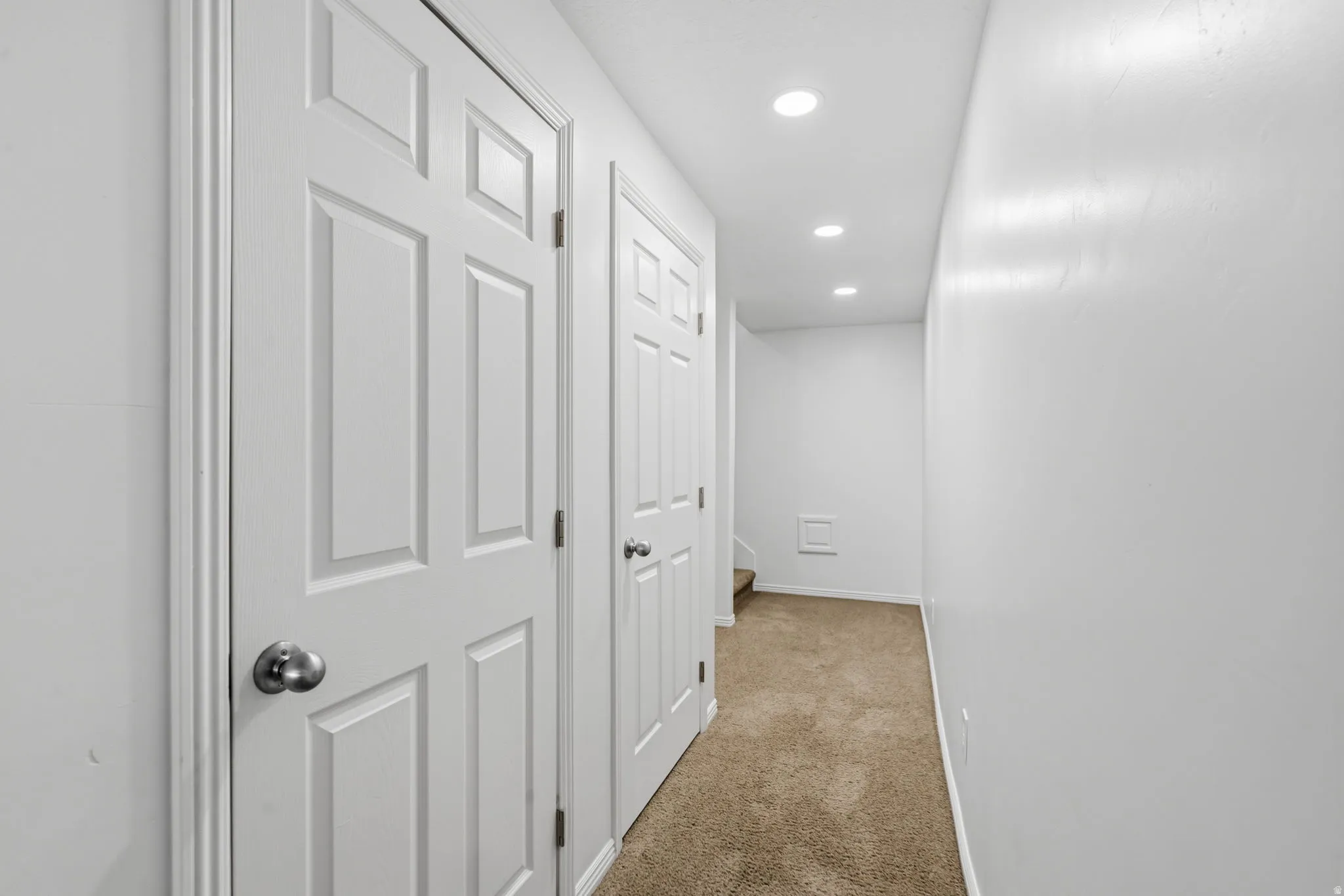 Recessed ceiling lighting, paneled doors, and neutral carpeting