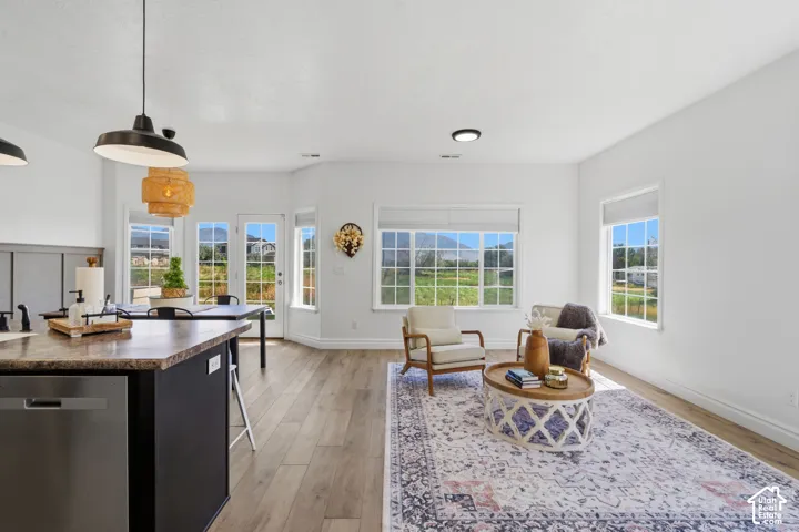 Open-concept interior featuring wood-finish flooring, white walls, and abundant natural light from multiple windows