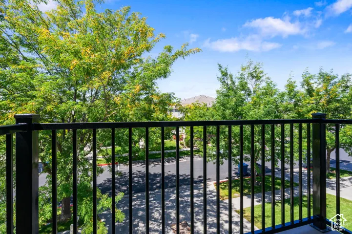 Black metal baluster railing overlooking a tree-lined street