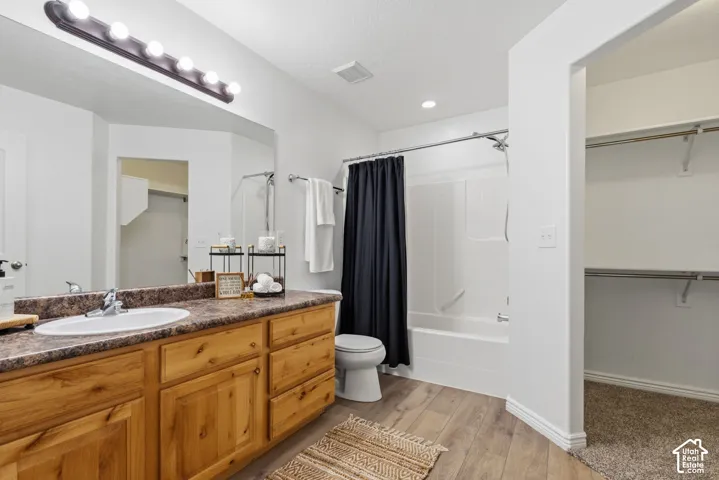 Vanity with wood-finish cabinetry, integrated sink, and vanity lighting