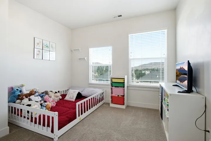 White walls with neutral carpet and two windows featuring blinds