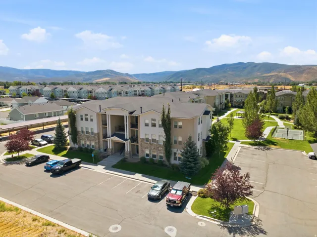 Multi-story building featuring stone and siding exterior, balconies, and a covered entryway