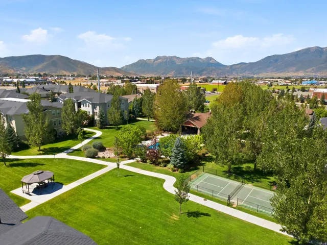 Expansive green space featuring winding pathways, a gazebo, and tennis courts