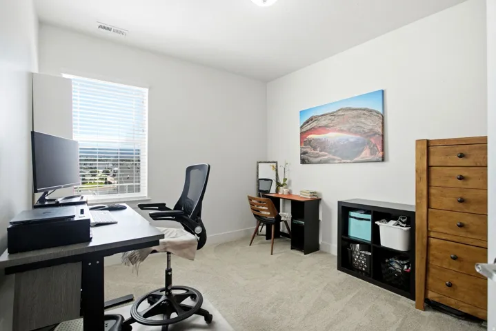 Carpeted room with a window featuring horizontal blinds