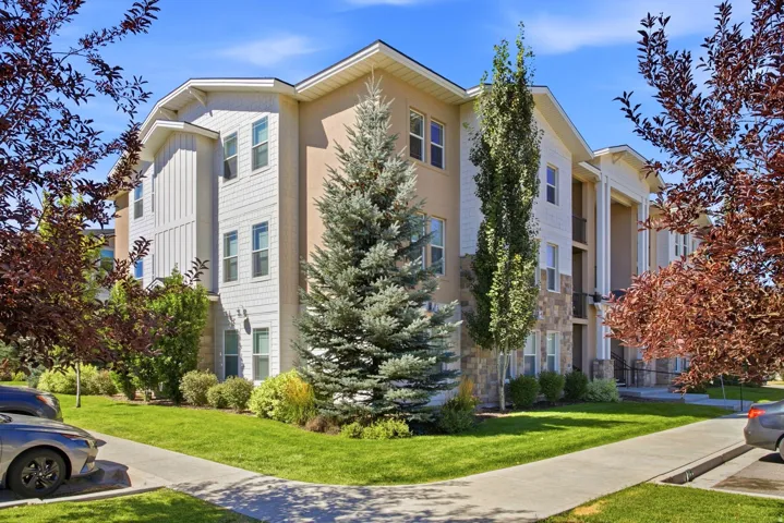Multi-story building with a blend of beige stucco and white horizontal siding