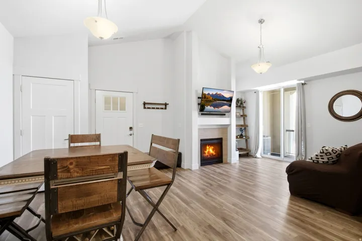 Open-concept living space with wood-finish flooring, a built-in fireplace, and a sliding glass door to an outdoor area