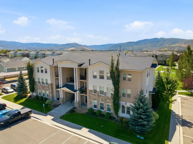 Multi-story building featuring a stone and stucco exterior, prominent entryway, and multiple balconies