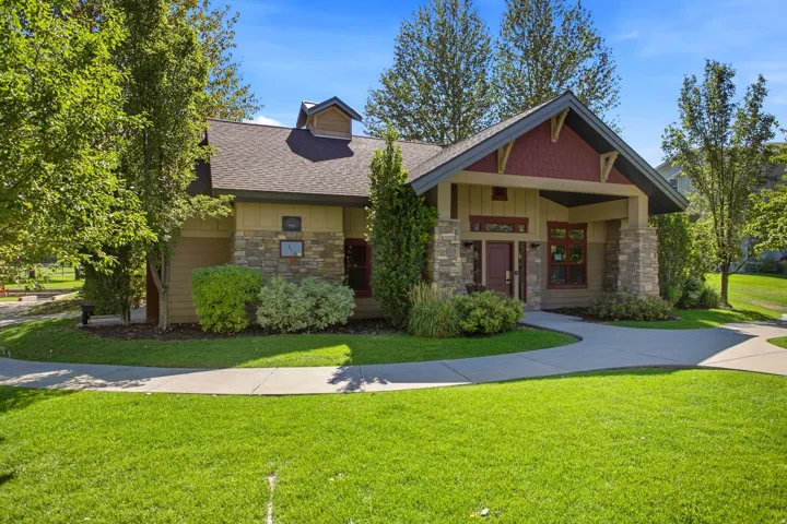 Craftsman-style exterior with stone columns, a covered entry, and shake siding accents