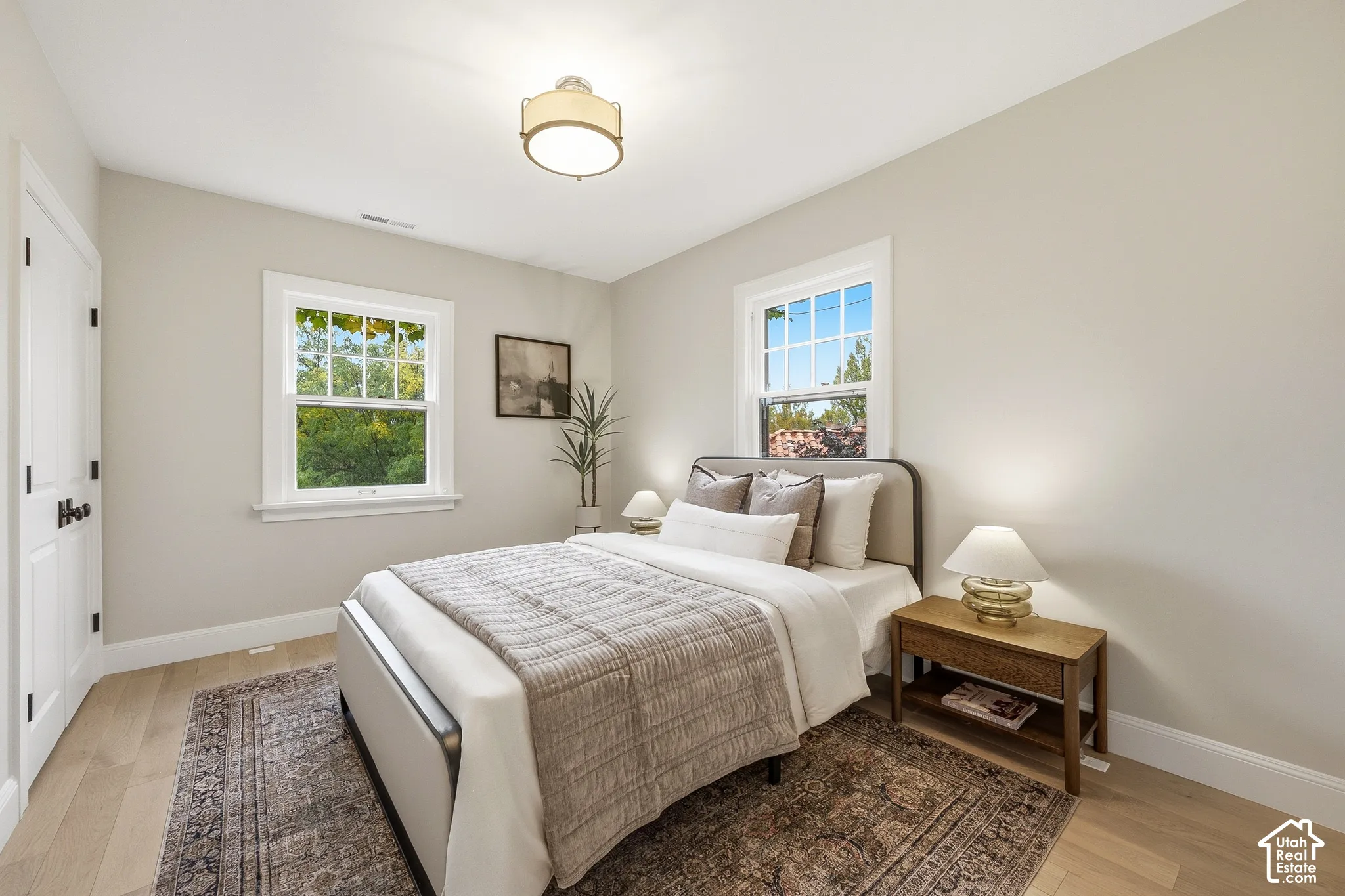 Second Bedroom. Light wood-finish flooring, white trim, and a flush mount ceiling fixture